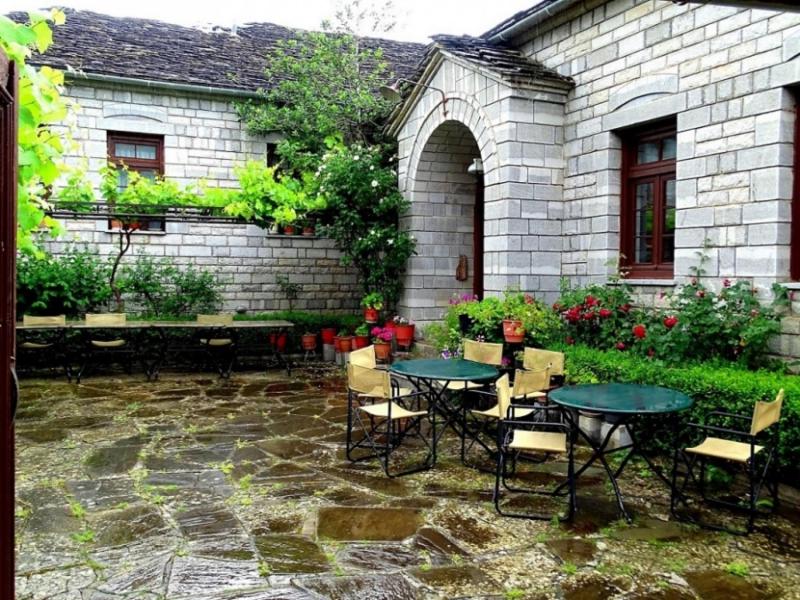 a patio with tables and chairs in front of a building at Hotel Papigo in Papigko