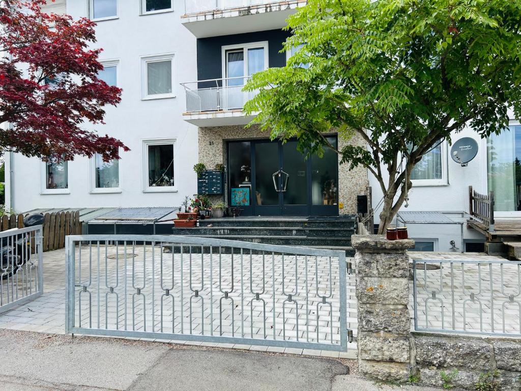 a white fence in front of a house at Charmante 3Zi-Ferienwohnung im Landhausstil in Kaufbeuren