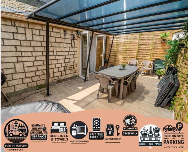 un patio con tavolo, sedie e muro di mattoni di SPACIEUX Appart Jacuzzi Terrasse Parking 10min port d'Honfleur Plage a Honfleur