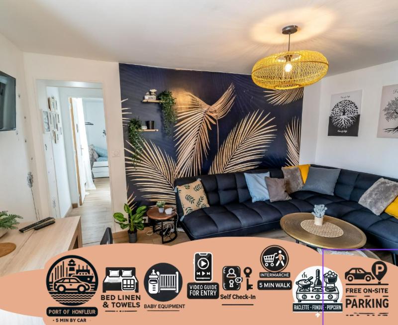 - un salon avec un canapé bleu et un mur dans l'établissement JUNGLE Appart 2 chambres parking 10min port Honfleur et plage, à Honfleur