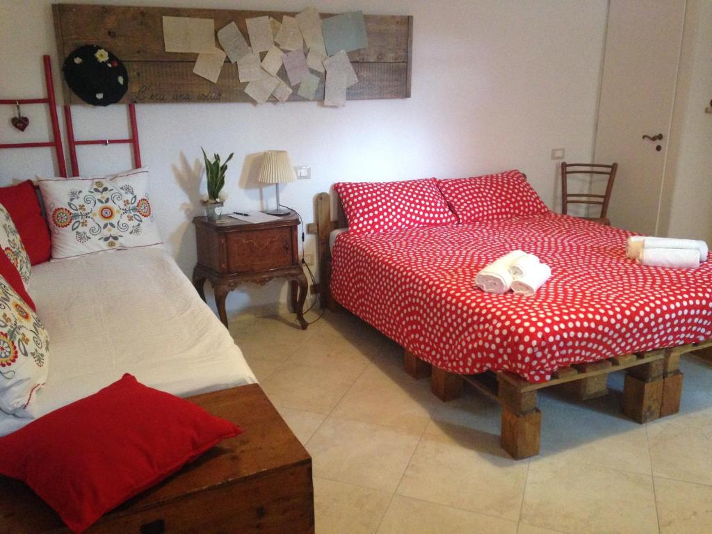 a bedroom with two beds with red and white sheets at C'era una volta in Asciano