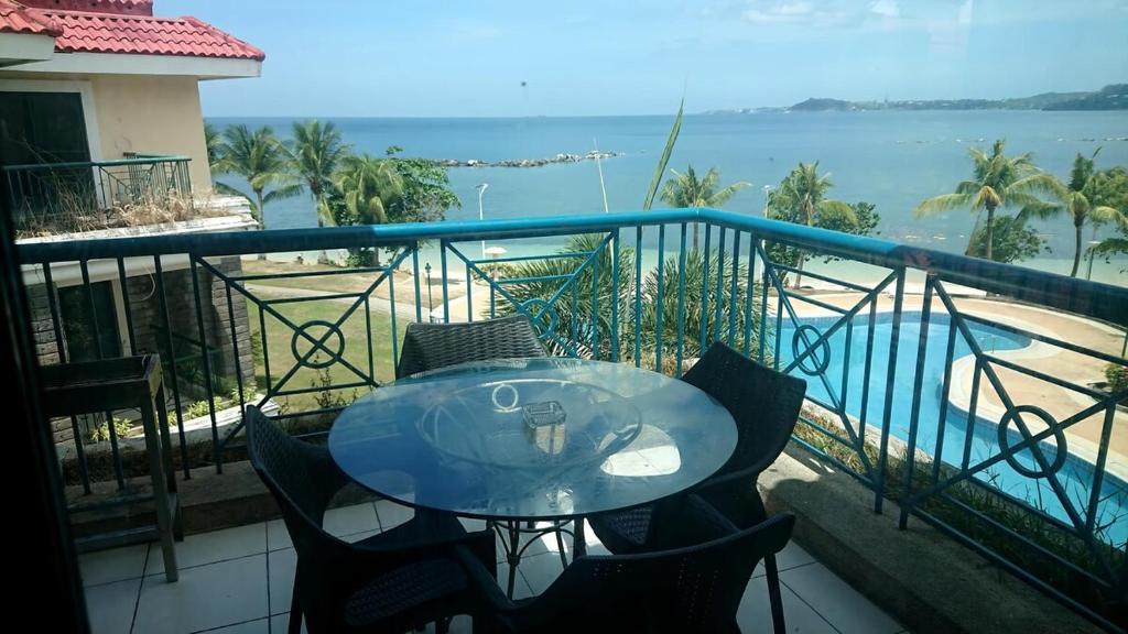 une table sur un balcon avec vue sur l'océan dans l'établissement Nasugbu Resort, Beachfront Condo in Canyon Cove A1-301, à Nasugbu
