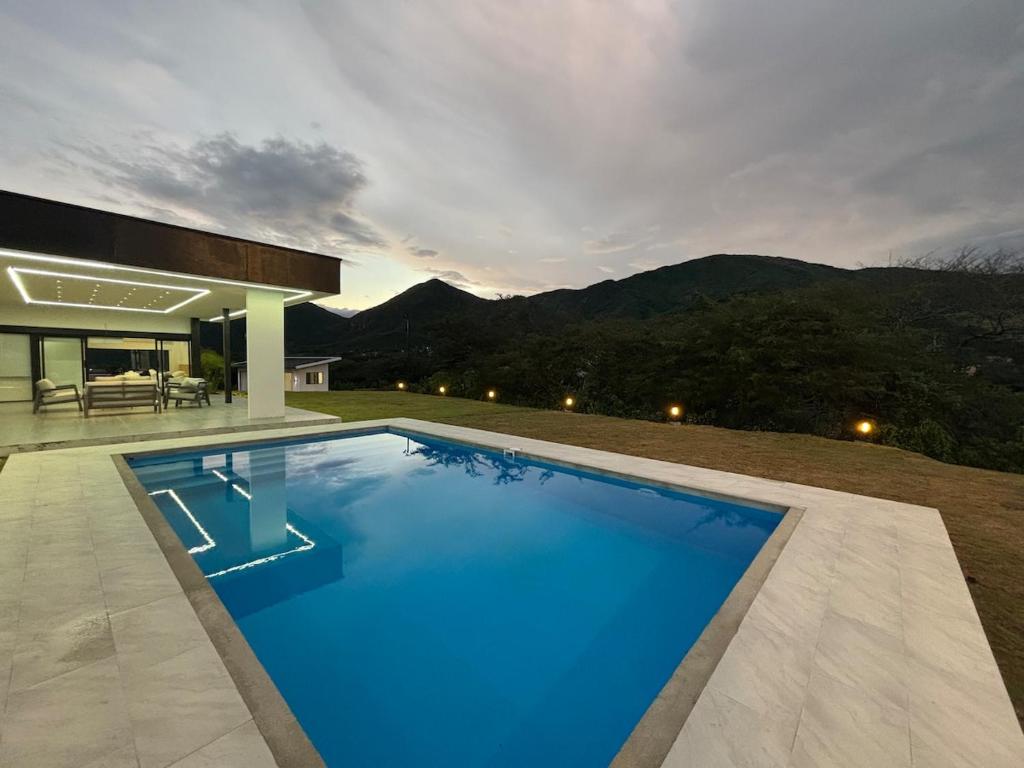 ein großer blauer Swimmingpool vor einem Haus in der Unterkunft Casa de lujo con piscina en Malacatos in Loja