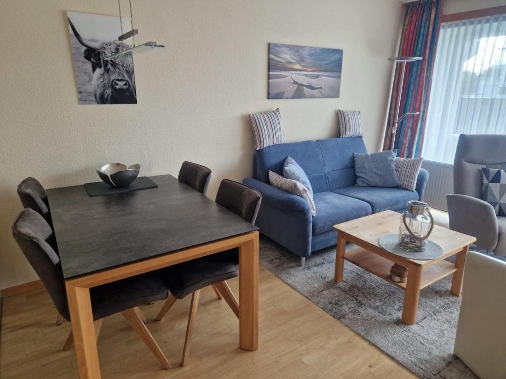a living room with a table and a blue couch at Germania-46 in Böhl