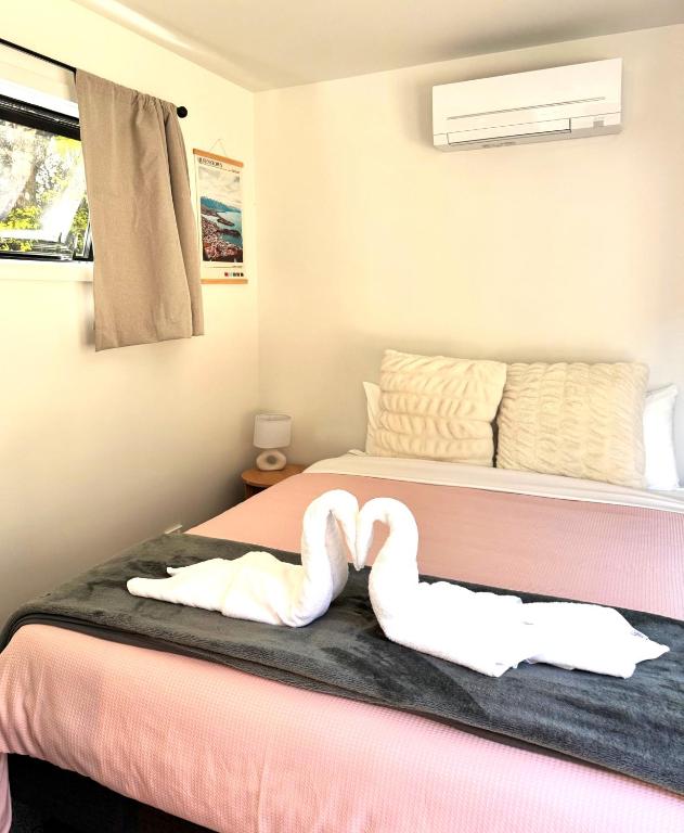 a bedroom with two swans laying on a bed at The Flaming Kiwi Backpackers in Queenstown