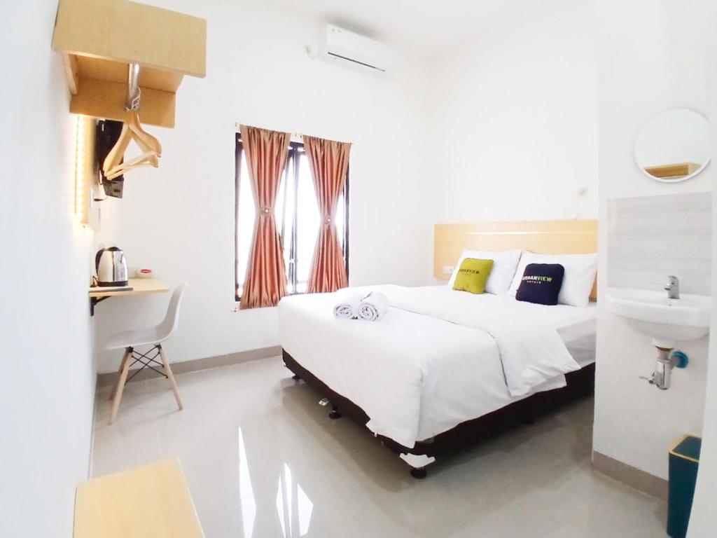 Postel nebo postele na pokoji v ubytování Urbanview Hotel Manggala Maguwoharjo