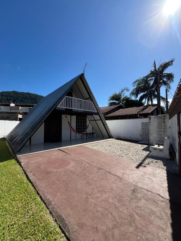 a house with a gambrel roof with a playground at Chalé em Ubatuba para 12 pessoas com Wi-Fi in Ubatuba