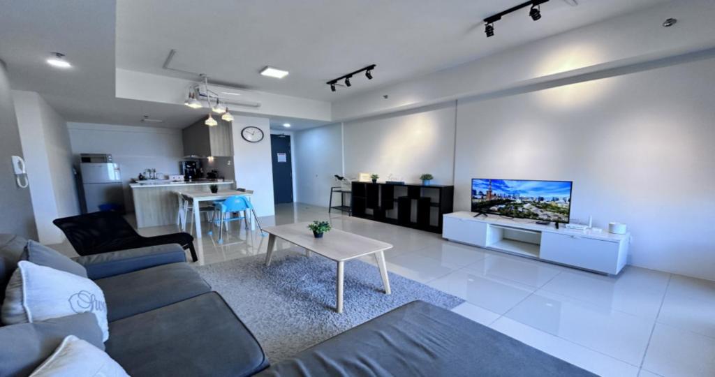 ein Wohnzimmer mit einem Sofa und einem Fernseher an der Wand in der Unterkunft 218 Macalister Food Paradise By Smart Space Home in George Town