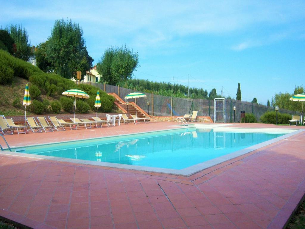 a large swimming pool with chairs and umbrellas at Varna Charm Tuscan Getaway in Querce