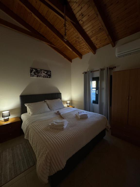 a bedroom with a large bed with two towels on it at Tholos Alexandra's Beachfront House in Kavoúsion