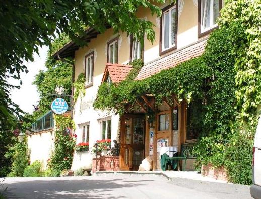 a street scene with a house and some trees at Hotel Restaurant - Häuserl im Wald Graz in Graz