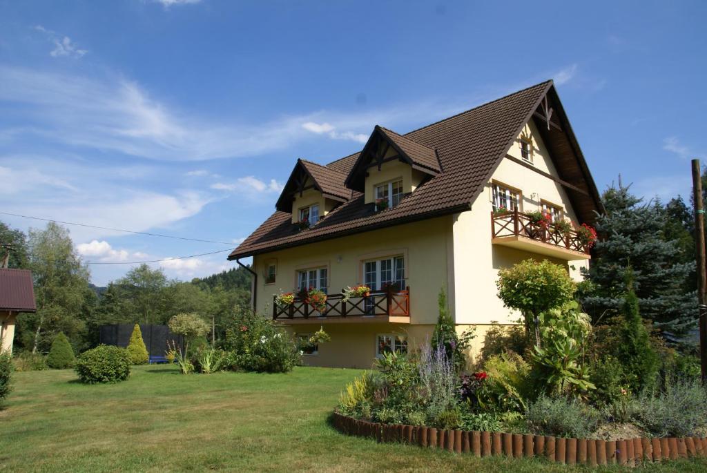 ein Haus mit einem braunen Dach und einem Hof in der Unterkunft Agroturystyka Leśny Zakątek in Stryszawa