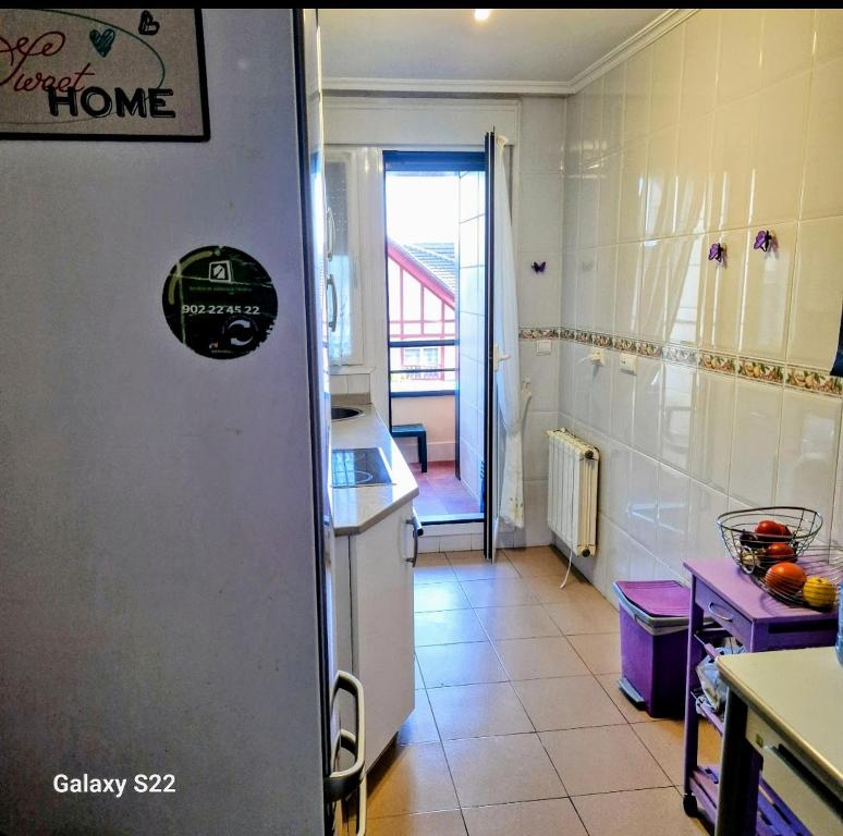 a kitchen with a white refrigerator in a room at Castro Urdiales in Castro-Urdiales