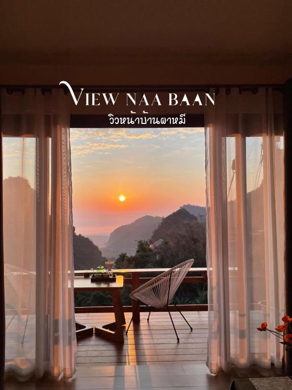 a room with a balcony with a view of the sunset at ViewNaaBaan At Phamee in Ban Pha Mi