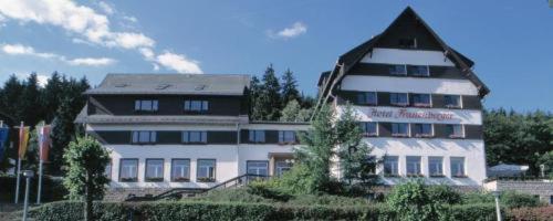 duży biały budynek z czarnym dachem w obiekcie Wagners Hotel im Thüringer Wald w mieście Bad Tabarz