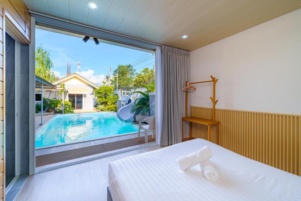 パタヤ・セントラルにあるCozy Gray Gardenのベッドルーム1室(ベッド1台付)、大きな窓(スイミングプール付)