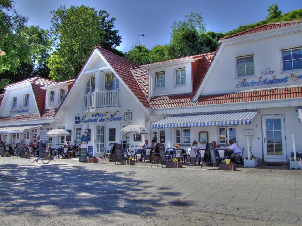 un grupo de personas sentadas en sillas frente de un edificio en Hotel Gastmahl des Meeres, en Sassnitz