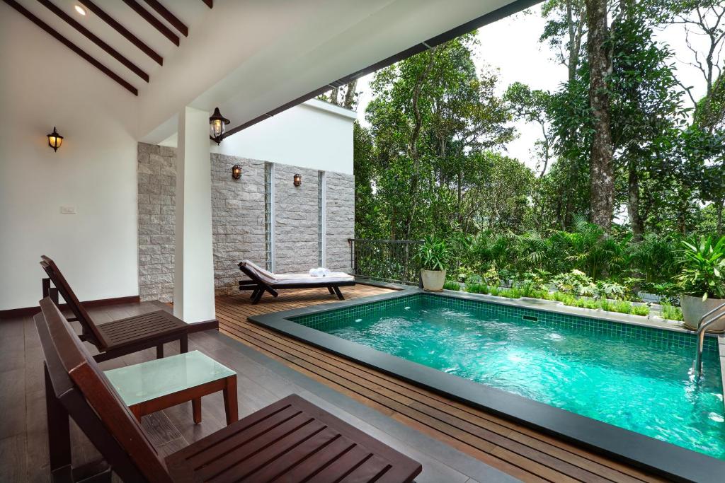 a swimming pool in the middle of a house at Reen Resorts Aanavilasam Plantation Thekkady in Thekkady