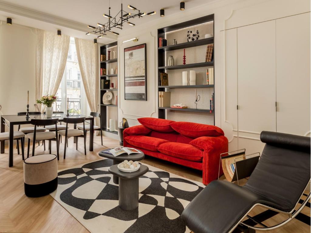 un salon avec un canapé rouge et une table dans l'établissement Merveil - Signature Suite - Marais - Montmartre, à Paris