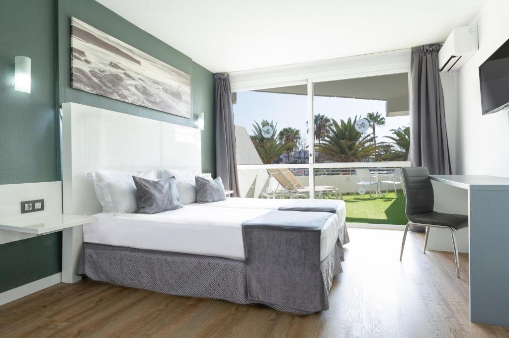 a bedroom with a large bed and a large window at Olé Tropical Tenerife Adults Only in Playa de las Americas