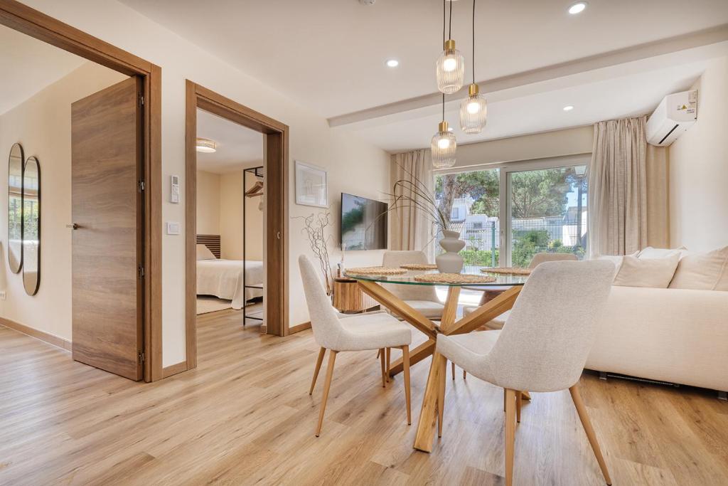 ein Esszimmer und ein Wohnzimmer mit Tisch und Stühlen in der Unterkunft Waves & Pines Apartment El Paraiso, Benamara in Estepona