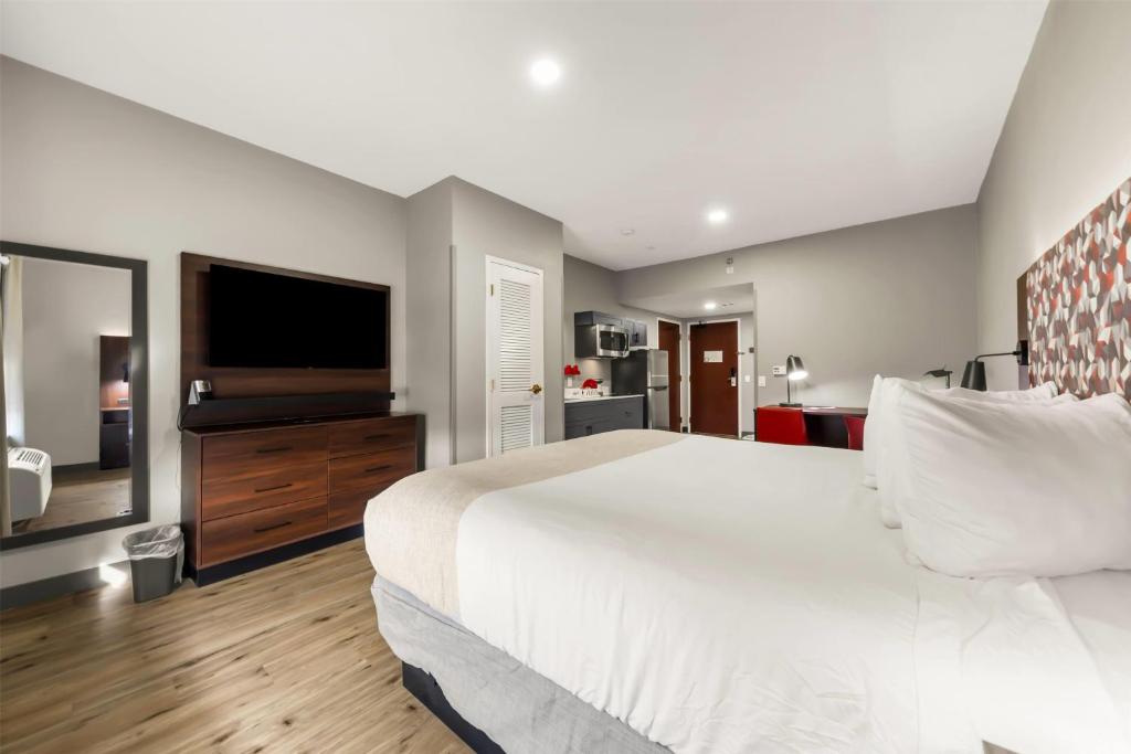 a bedroom with a large bed and a flat screen tv at Hawthorn Extended Stay by Wyndham College Station in College Station