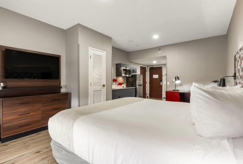 a bedroom with a large bed and a flat screen tv at Hawthorn Extended Stay by Wyndham College Station in College Station