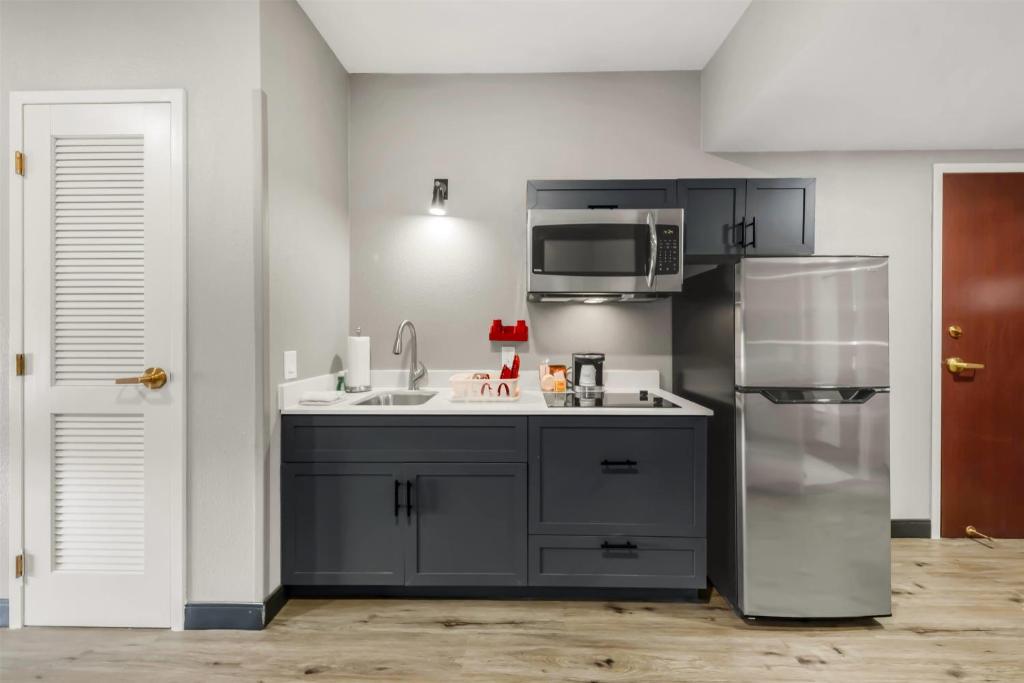 a kitchen with a sink and a refrigerator at Hawthorn Extended Stay by Wyndham College Station in College Station