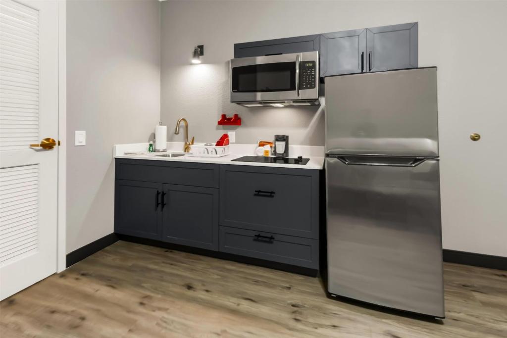 a kitchen with a stainless steel refrigerator and a sink at Hawthorn Extended Stay by Wyndham College Station in College Station