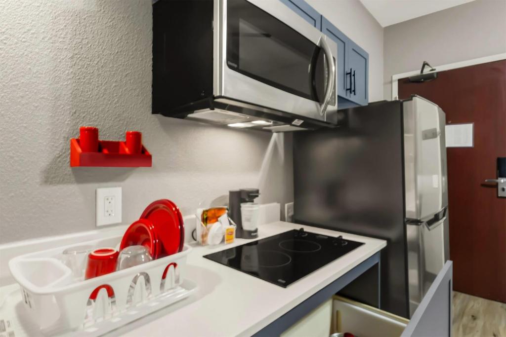 a kitchen with a sink and a refrigerator at Hawthorn Extended Stay by Wyndham College Station in College Station