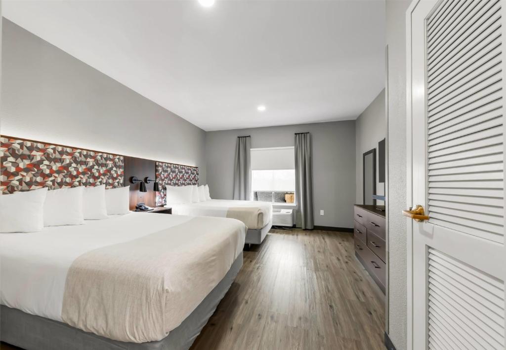a hotel room with two beds and a window at Hawthorn Extended Stay by Wyndham College Station in College Station