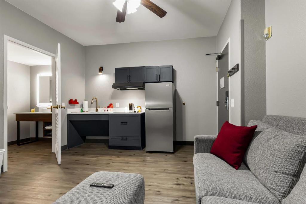 a living room with a couch and a kitchen at Hawthorn Extended Stay by Wyndham College Station in College Station