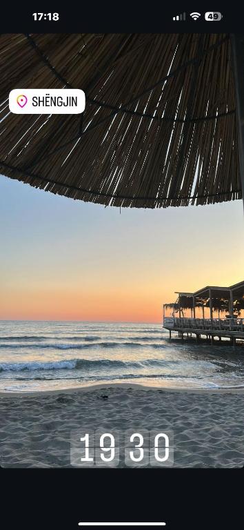 ein Bild von einem Strand mit einer Uhr darauf in der Unterkunft Your beach house holidays with all utilities in Shëngjin