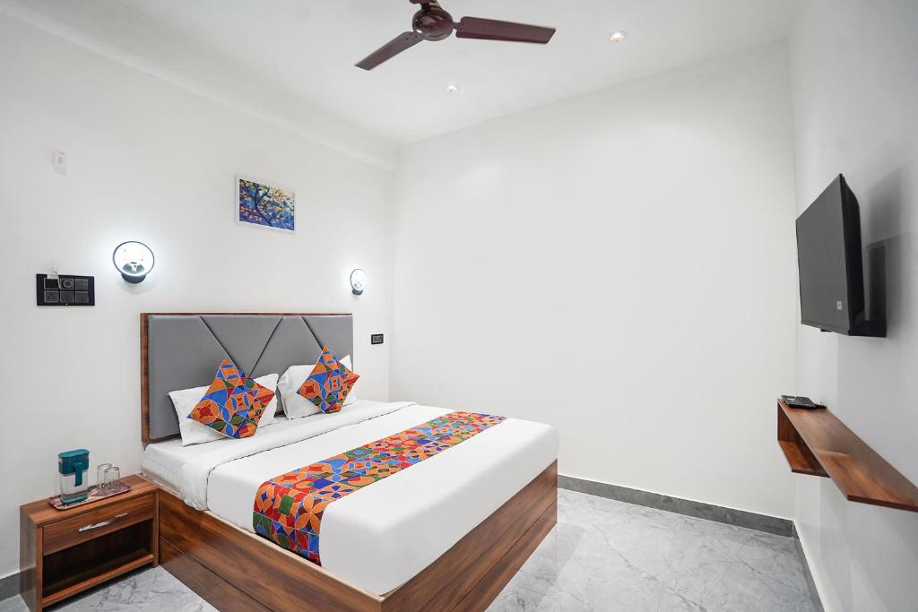 バラナシにあるFabHotel The Shivaay Palaceのベッドと薄型テレビのある寝室