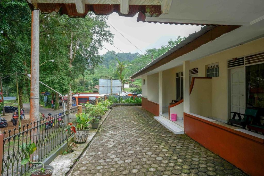 a house with a walkway next to a street at RedDoorz near Lokawisata Baturaden 2 in Tenjo