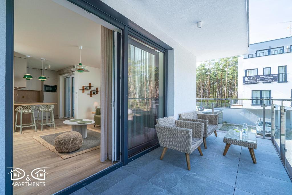 a living room with sliding glass doors and a balcony at Apartament Zielony D&D APARTMENTS in Międzywodzie