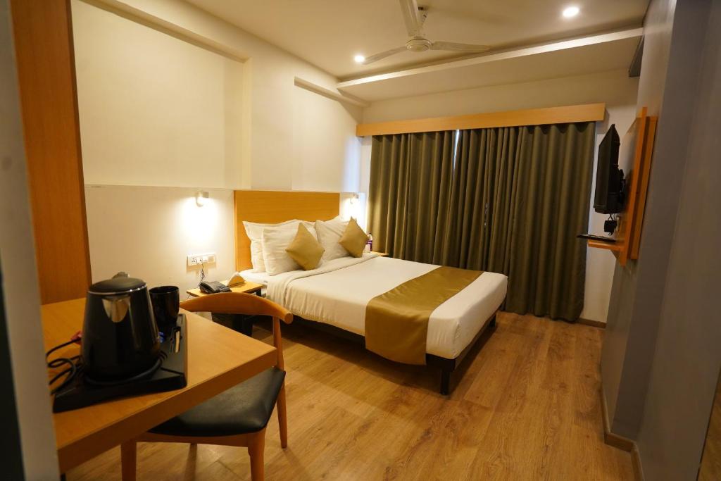 una habitación de hotel con una cama y un escritorio en The Byke Landmark - Near C21 Mall, en Indore