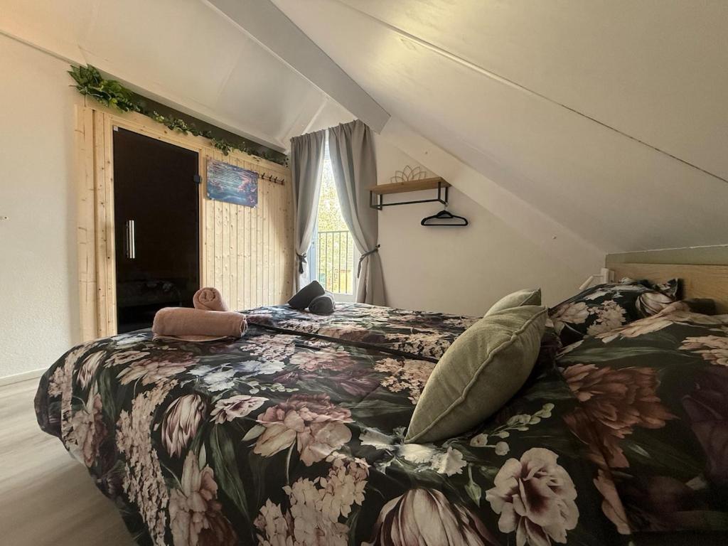 Un dormitorio con una cama con una colcha floral. en Pure Wellness with massage, en Ewijk