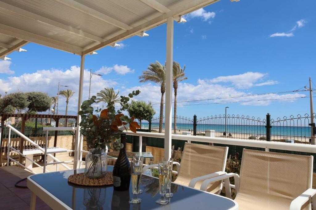 a table with a vase of flowers on a patio at Increíble casa frente a la playa de Muchavista Alicante By ElConserje in El Campello