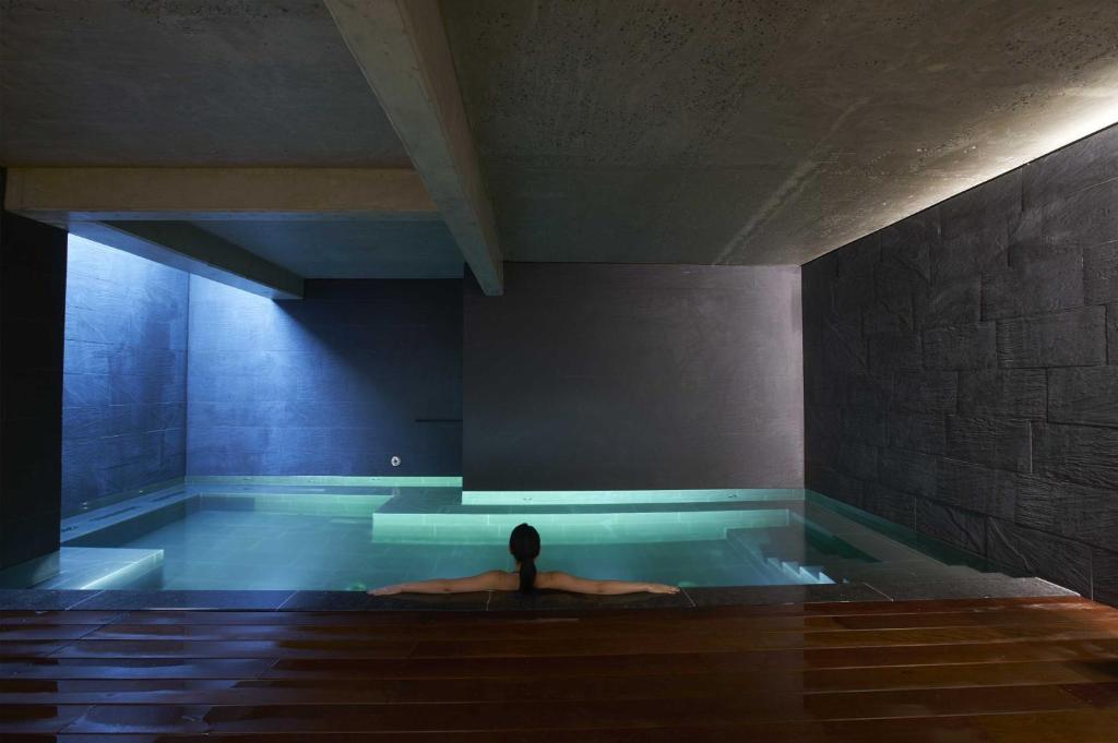 una persona sentada en una piscina en una habitación en 9Hotel Sablon, en Bruselas