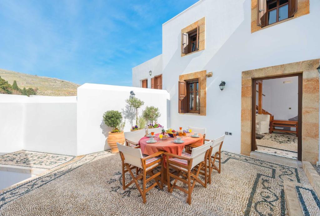 Residenza Maria Lindos Villa في ليندوس: غرفة طعام مع طاولة وكراسي