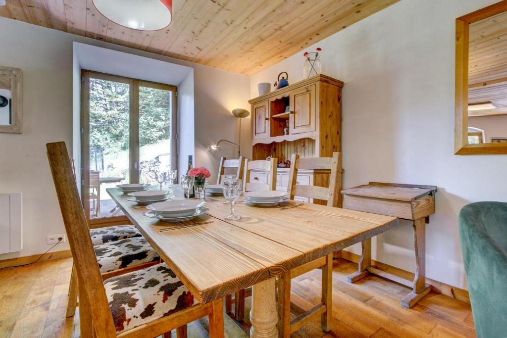 une salle à manger avec une table et des chaises en bois dans l'établissement Chalet la Ficle, à Saint-Jean-dʼAulps