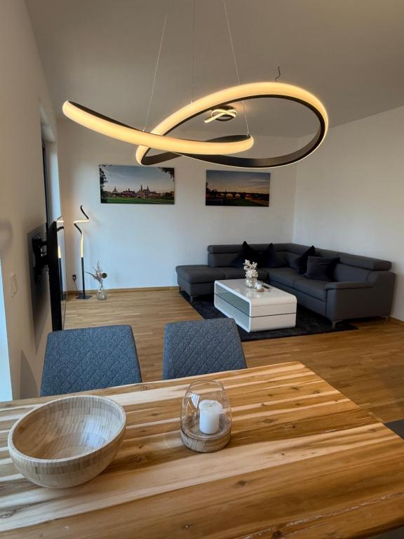 ein Wohnzimmer mit einem Holztisch mit einer Schüssel darauf in der Unterkunft ElbeCity Apartment in Dresden