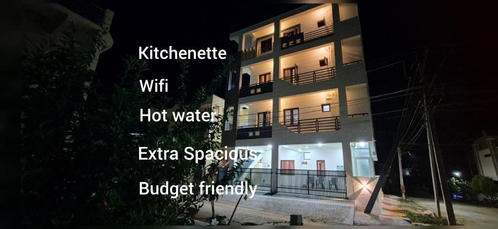 a building at night with the wordsustainable with hot water extra spontaneousbudget friendly at Chiraanya Service Apartment in Chikmagalūr