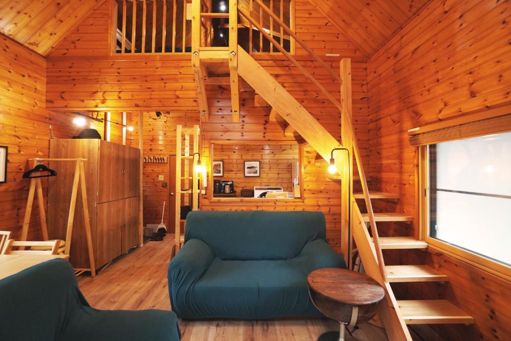 a living room with a blue couch and a staircase at The Creek Cottage in Habu