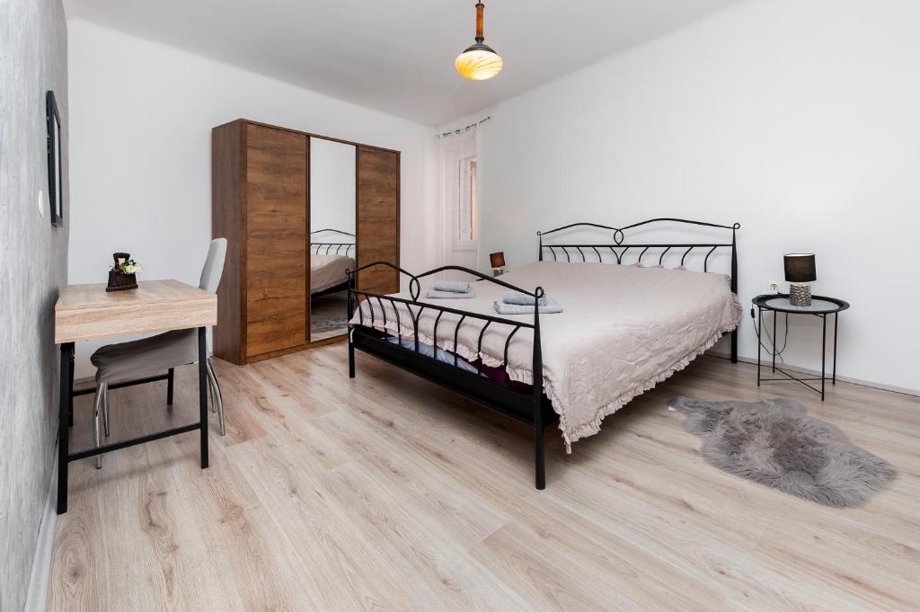 sypialnia z łóżkiem, stołem i biurkiem w obiekcie Apartment 1900 w Rovinj