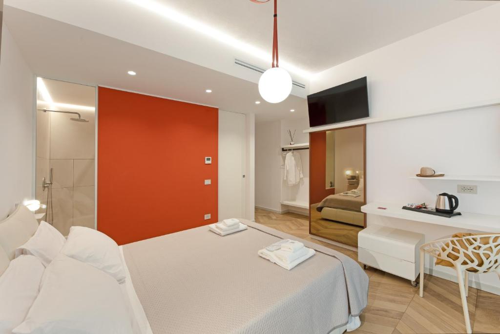 a bedroom with a bed and a red door in it at Elisea Your City Escape in Polignano a Mare