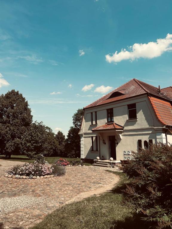 a small white house with a red roof at Landhausvilla Gut Vogelsang in Lalendorf