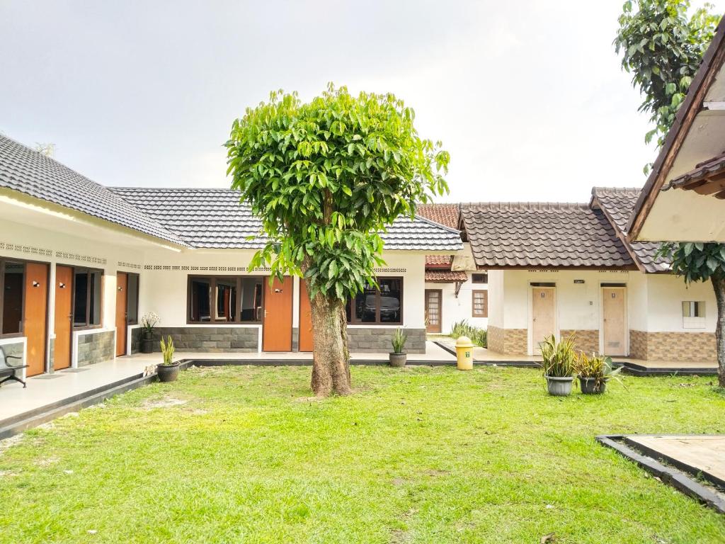 an image of a house with a tree in the yard at Roemah Kavaleri powered by Cocotel in Bandung