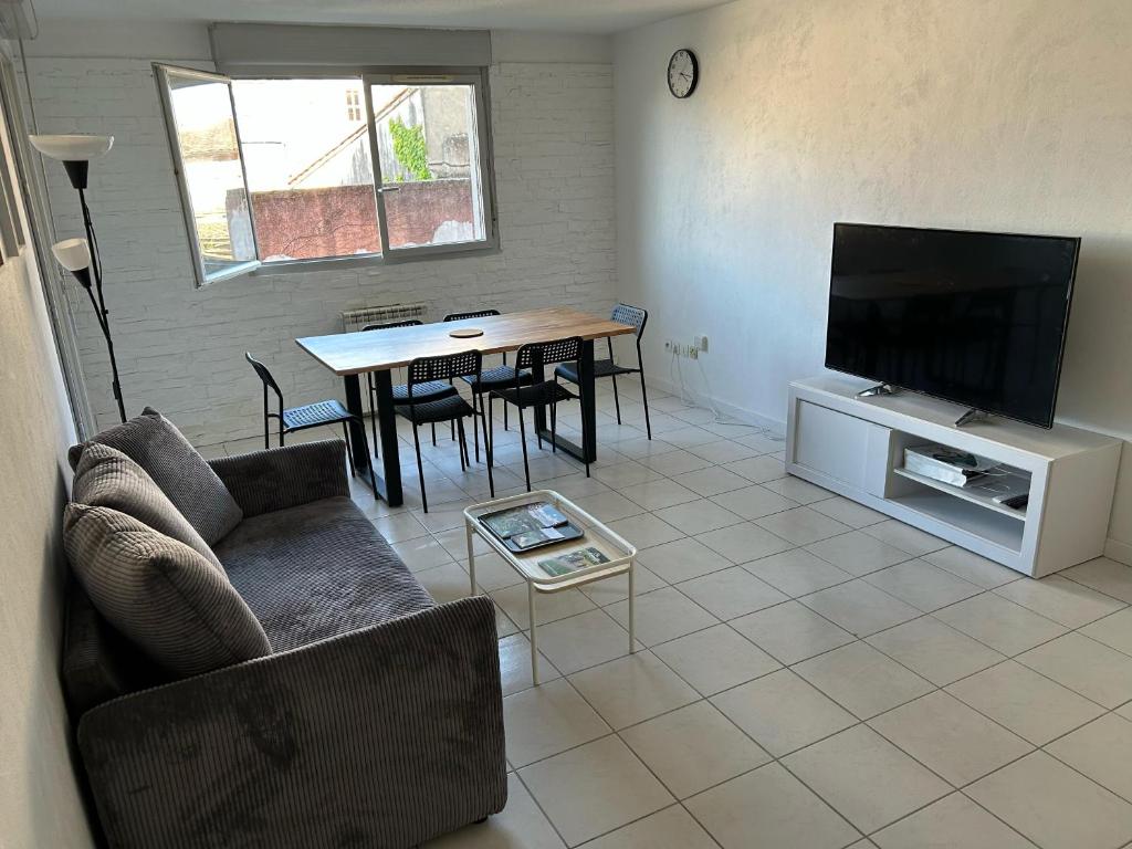 un salon avec un canapé et une table avec une télévision dans l'établissement Appartement centre ville avec place de parking privée et balcon, à Montauban